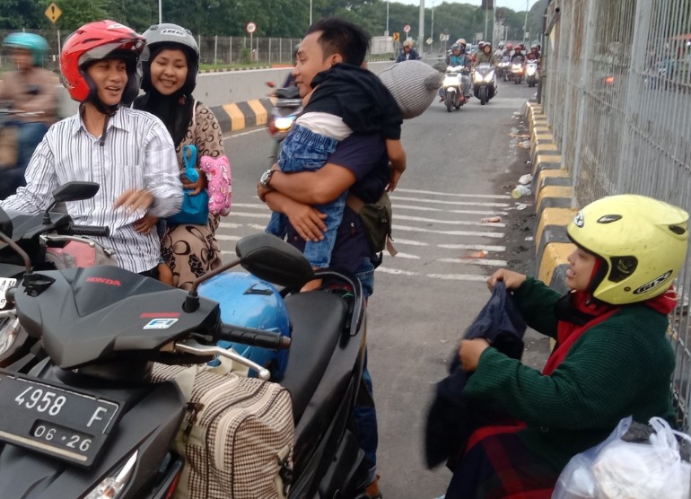 ISTIRAHAT: Pemudik terlihat istirahat di tepi jalan Jembatan Suramadu, Senin (8/4) sore.