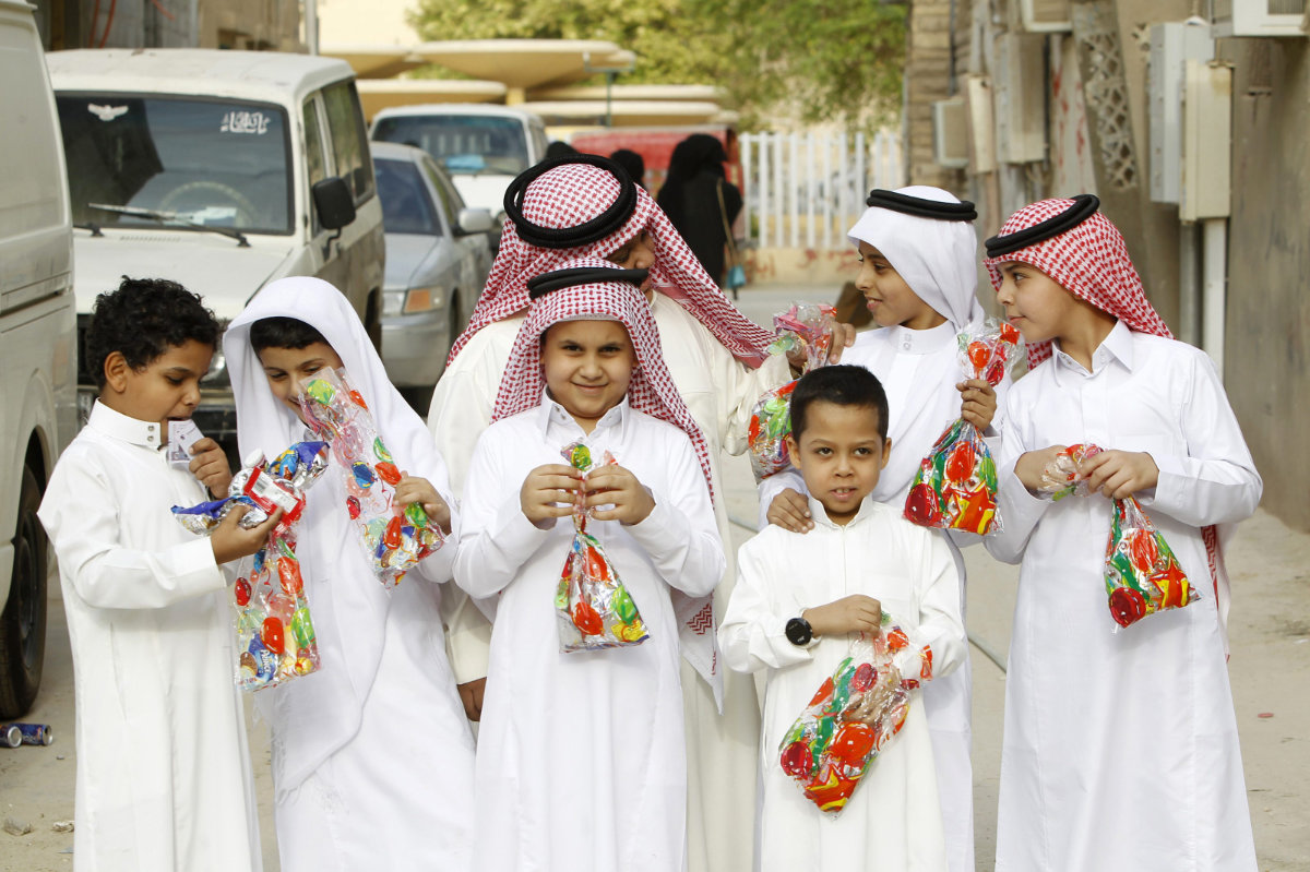 Anak-anak di Arab Saudi saat Idul Fitri memakai pakaian baru dan berbagai manisan.
