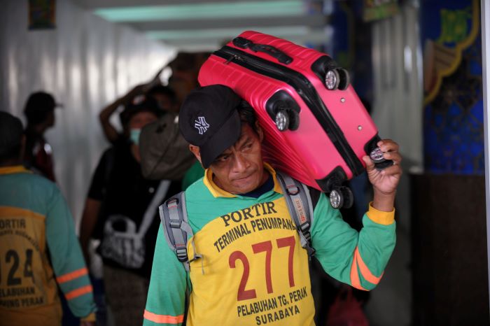 BERKAH: Porter di Stasiun Surabaya Gubeng saat mengangkut barang penumpang. Selama arus mudik lebaran jasa porter ketiban rezeki dari para pemudik yang menggunakan jasanya. (ANDY S/RADAR SURABAYA)