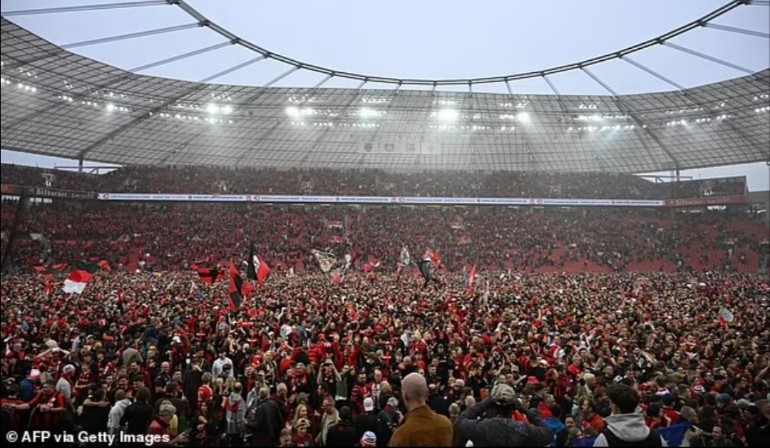 Suporter Bayer Leverkusen tumpah ruah di lapangan BayArena usai wasit meniup peluit panjang.