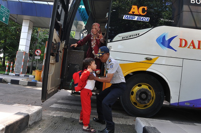 BALIK: Penumpang saat turun dari bus di Terminal TOW yang mengantarkan dari berbagai daerah di Jawa Timur dan Jawa Tengah usai libur lebaran, Selasa (16/4). (ANDY S/RADAR SURABAYA)