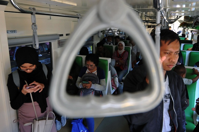 FULL: Sejumlah penumpang kereta api local atau commuter line dengan tujuan beberapa daerah di Jatim, menaiki kereta di Stasiun Surabaya Gubeng Lama, Senin (15/4).