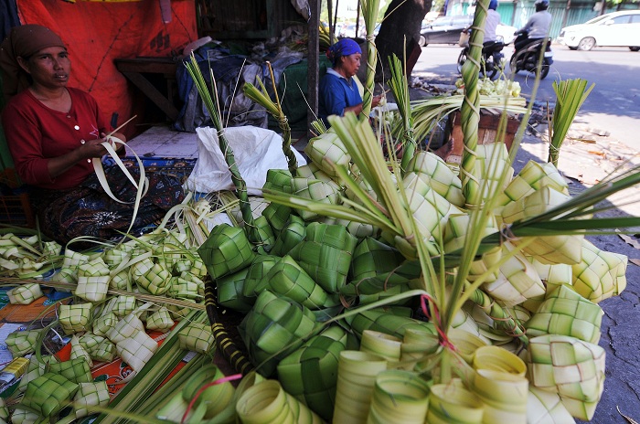 PERAJIN KETUPAT: Maisaroh, perajin ketupat asal Bangkalan, Madura ditemani anaknya menjual hasil kerajinannya di kawasan Pasar Keputran Selatan, Senin (15/4). (ANDY S/RADAR SURABAYA)
