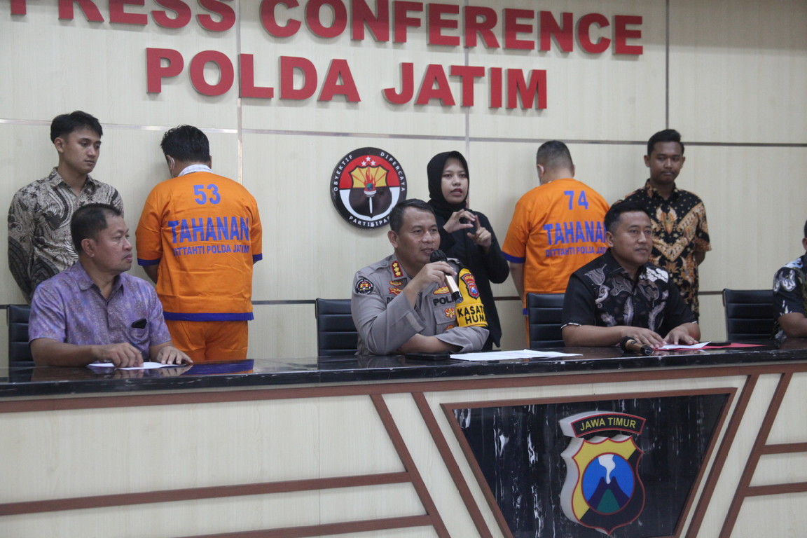 Petugas menunjukkan barang bukti dan tersangka kasus penipuan yang berhasil diamankan di Mapolda Jatim, Jalan Ahmad Yani, Surabaya (Suryanto/Radar Surabaya).