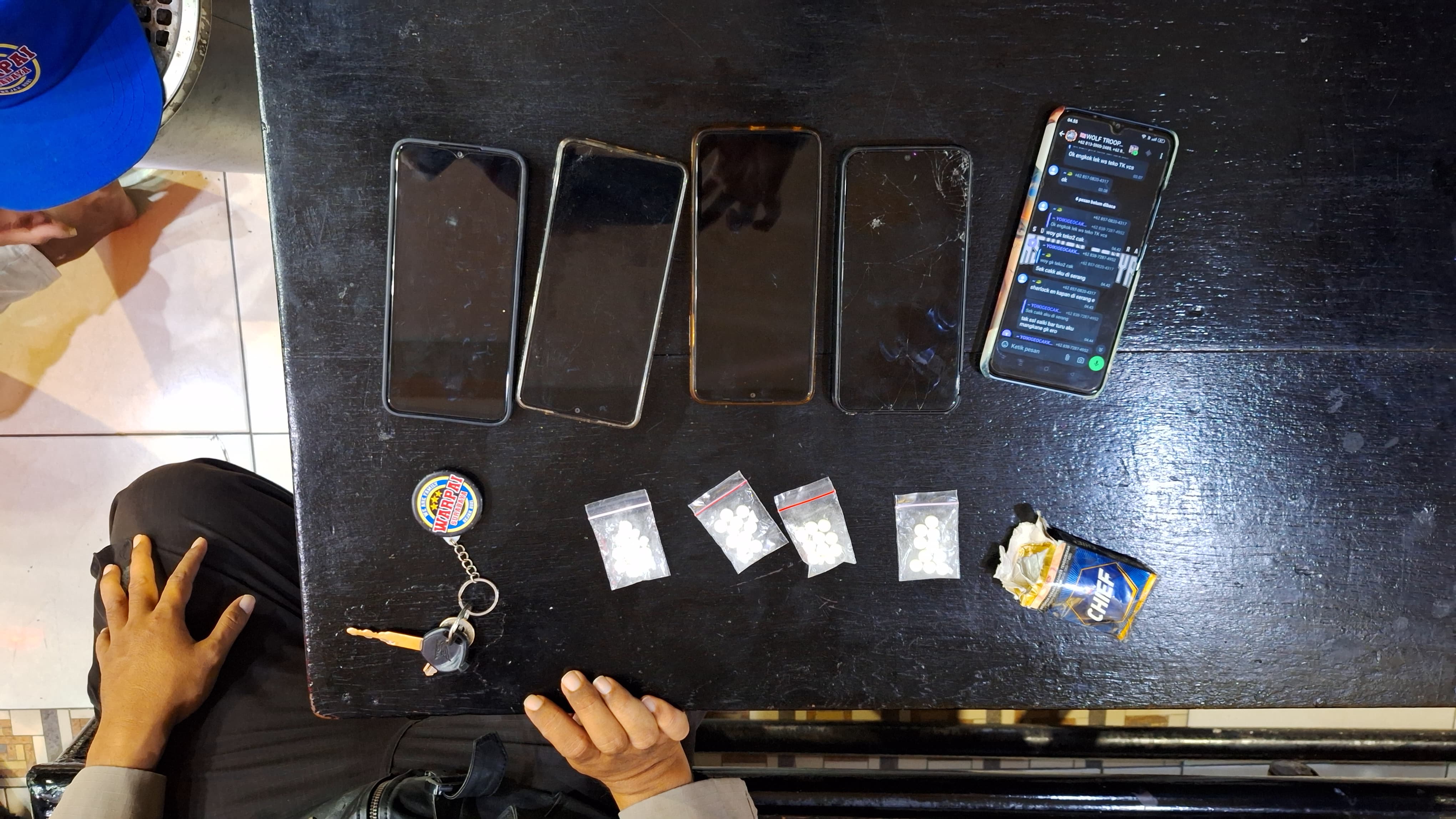 Pil LL dan handphone yang diamankan dari tujuh remaja anggota geng di Surabaya.