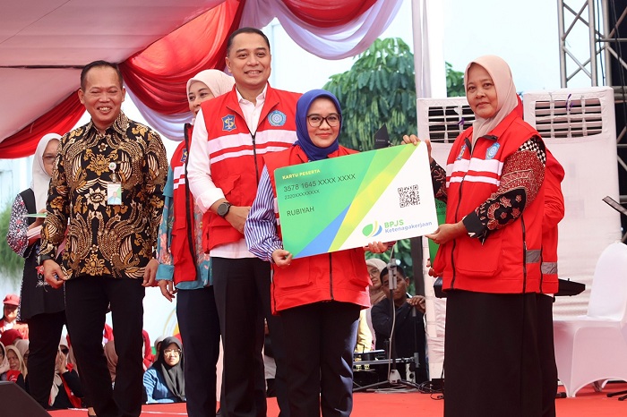 BAHAGIA: Wali Kota Surabaya Eri Cahyadi didampingi Ketua TP PKK Kota Surabaya Rini Eri Cahyadi secara simbolis menyerahkan BPJS kepada perwakilan KSH di halaman Balai Kota Surabaya, Senin (29/4).