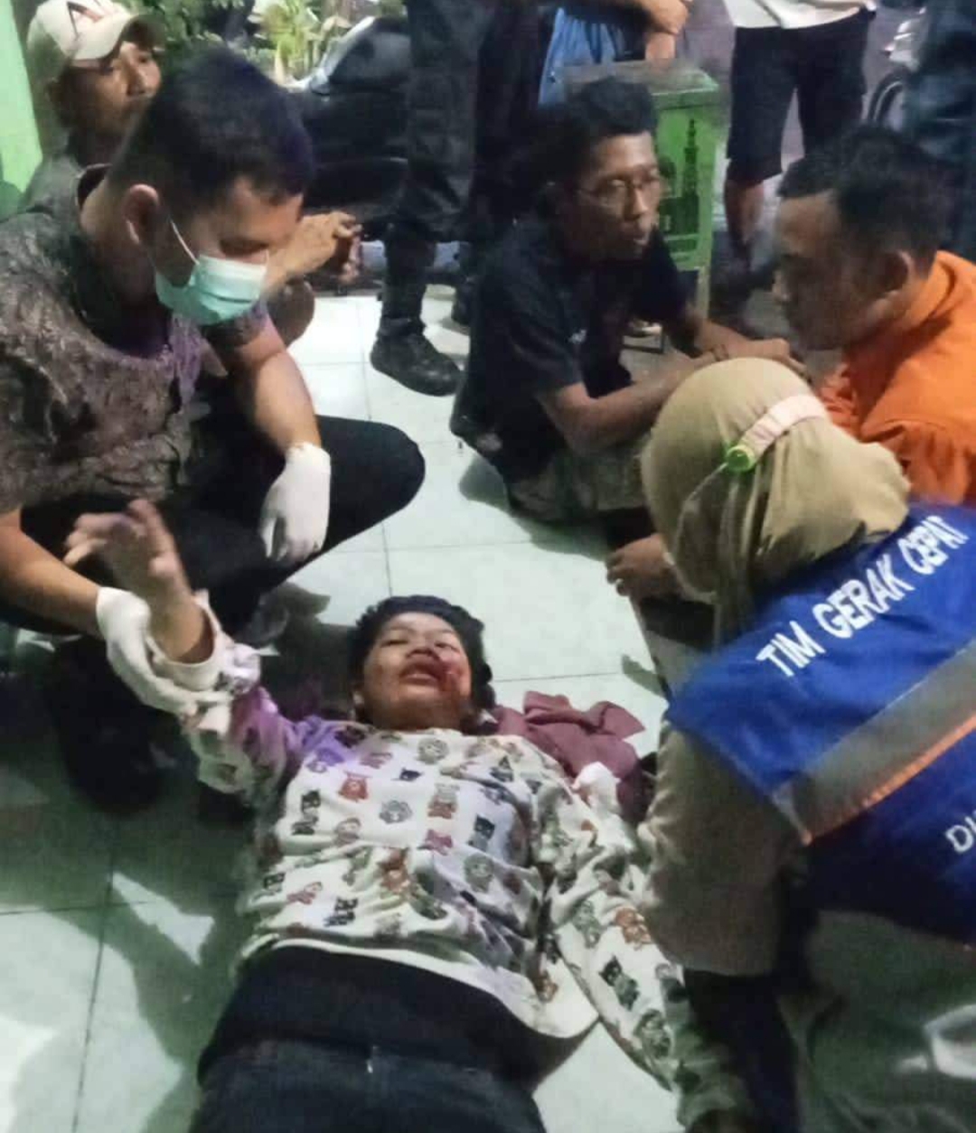 Petugas memberi pertolongan awal kepada korban kecelakaan dan jambret di Simo Jawar, Surabaya (IST).