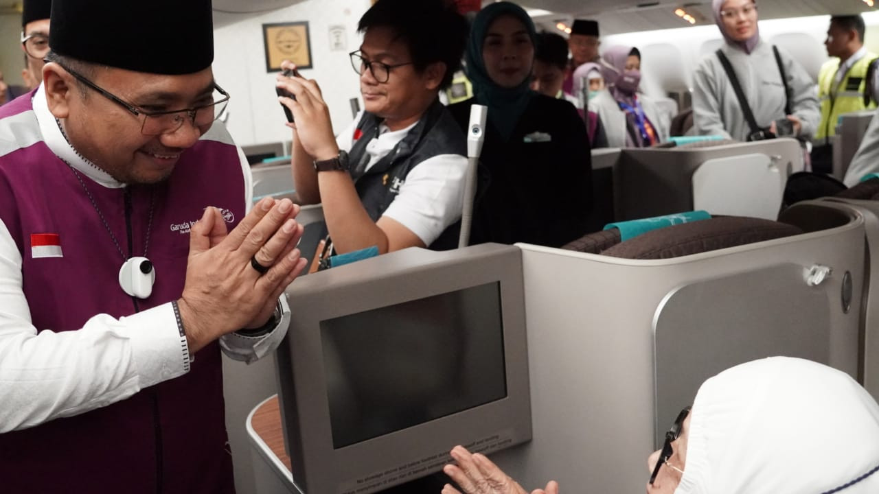 HORMAT: Menag menyapa jemaah di pesawat menjelang keberangkatan ke Tanah Suci melalui Embarkasi Jakarta-Pondok Gede (JKG-01) di Bandara Soekarno-Hatta (Soetta), Minggu (12/5) dini hari. (IST)