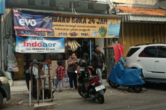 BUKA 24 JAM: Warga membeli berbagai macam kebutuhan di salah satu warung madura di kawasan Peneleh, Surabaya. (SURYANTO/RADAR SURABAYA)