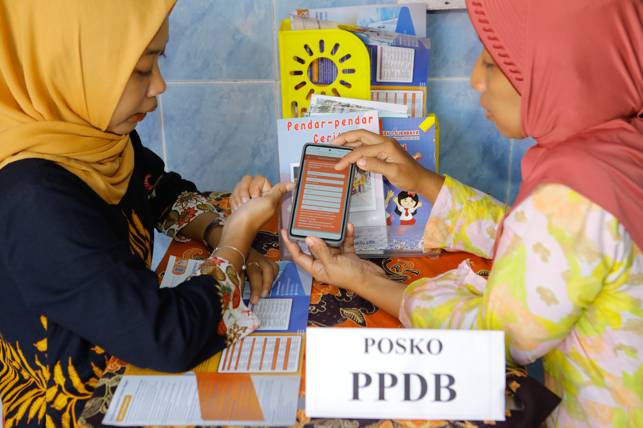 PENJELASAN: Calon wali murid mendapatkan informasi tentang PPDB di Posko PPDB SDN Peneleh I, Surabaya, Kamis (16/5). (SURYANTO/RADAR SURABAYA)
