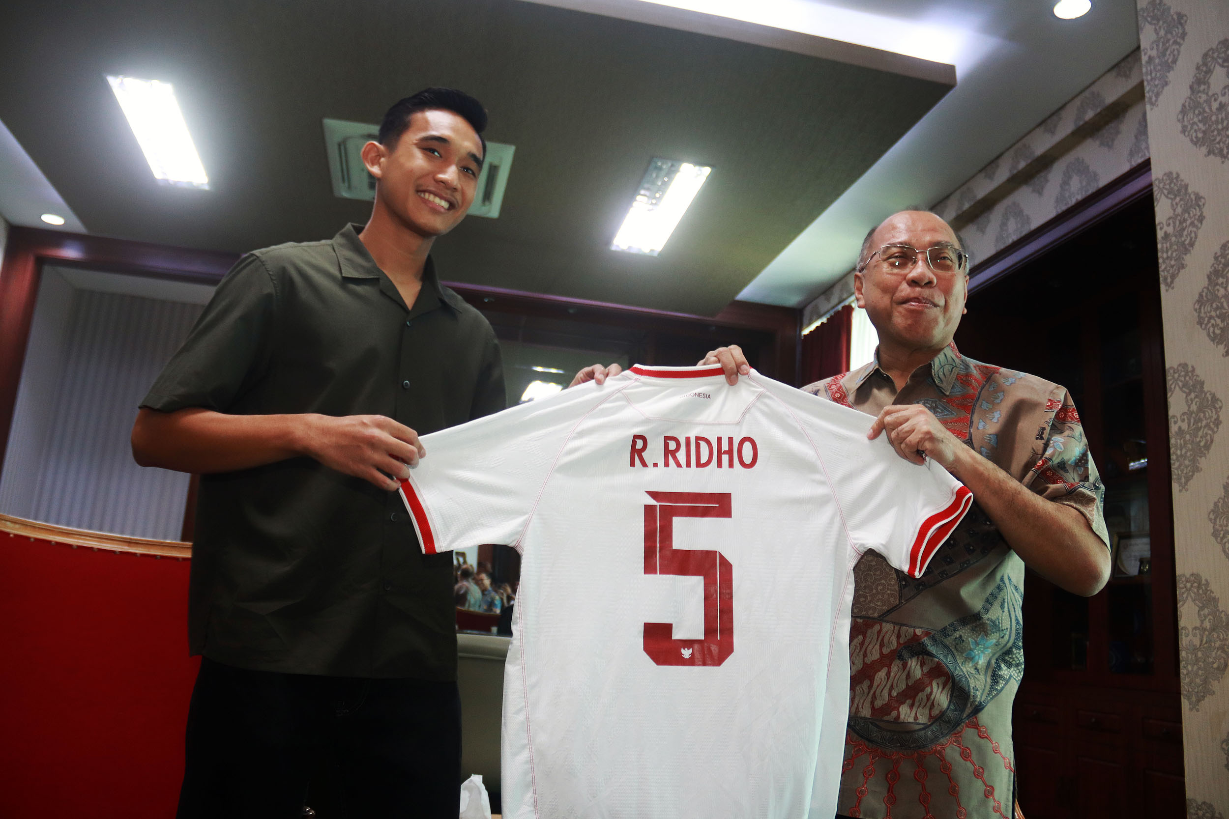 Kapten Indonesia U-23 Rizky Ridho memberikan jersey-nya kepada Rektor Universitas Muhammadiyah (UM) Surabaya Sukadiono, Jumat (17/5)- ANDY SATRIA/RADAR SURABAYA&nbsp;