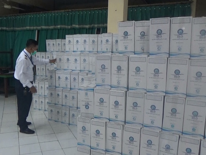 TIBA: Petugas tengah mengecek ribuan air zamzam dalam kemasan dus yang diletakan di Gedung F1 Asrama Haji Embarkasi Surabaya, Senin (27/5). (RAHMAT SUDRAJAT/RADAR SURABAYA)