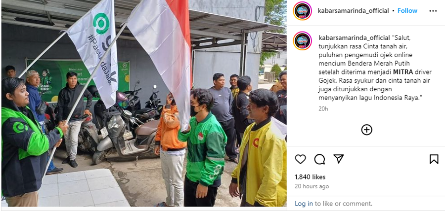 Pengemudi online mencium bendera sebagai bentuk syukur dan cinta tanah air karena diterima menjadi mitra Gojek sebagai aplikasi karya anak bangsa.