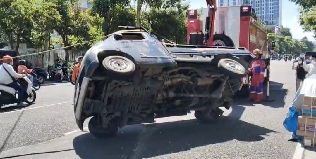 Petugas mengevakuasi muatan mobil ke tepi jalan (Mahrus/Radar Surabaya).