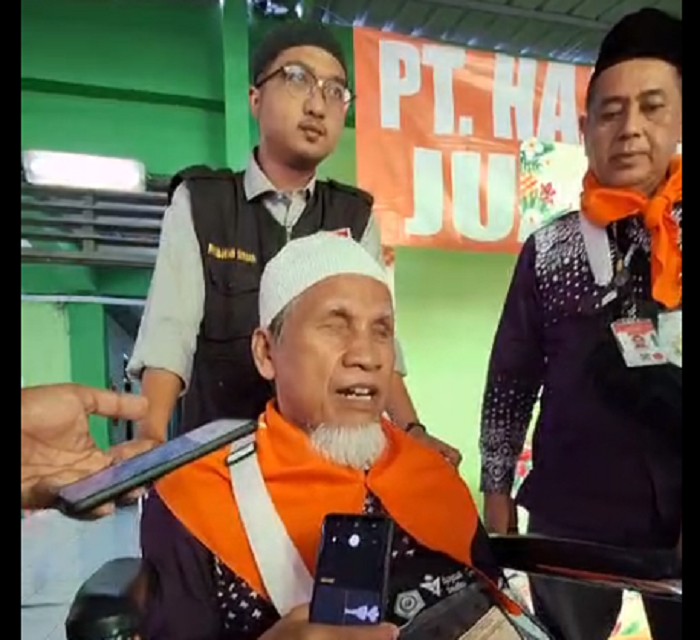 SEMANGAT: Kasiyo yang duduk di atas kursi roda dibantu petugas saat tiba di Asrama Haji Embarkasi Surabaya (AHES), Kamis (30/5). (RAMHAT SUDRAJAT/RADAR SURABAYA)