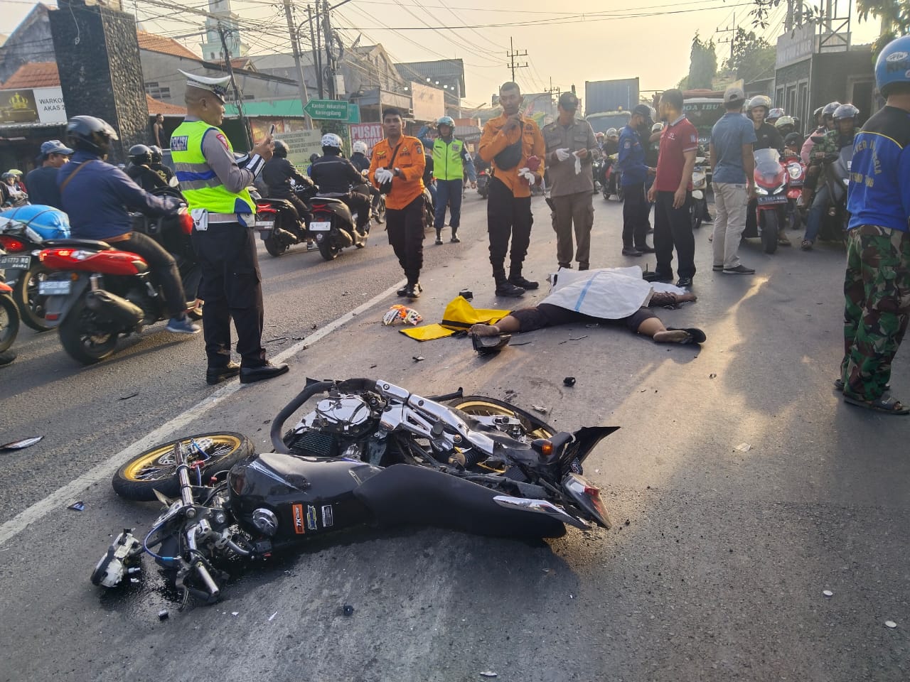 Petugas mengevakuasi mayat Adit Widodo, 20, untuk dibawa ke RSUD dr Soetomo setelah dilindas truk di Jalan Mastrip, Surabaya, Senin (3/6) pagi (IST).