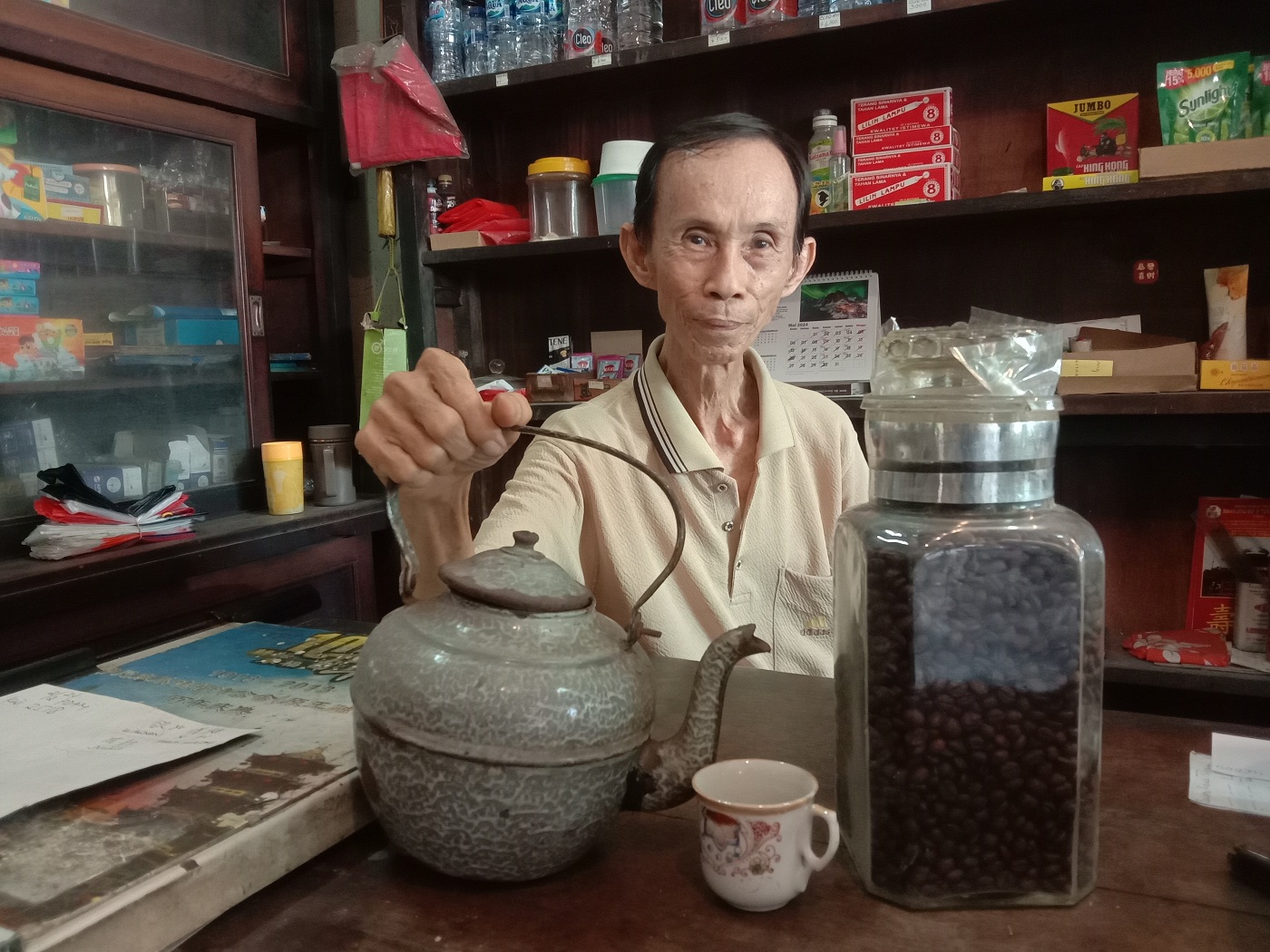 LEGENDARIS: Gunawan menunjukkan ceret dan cangkir peninggalan almarhum ayahnya, Sigan, yang digunakan untuk menyeduh kopi.