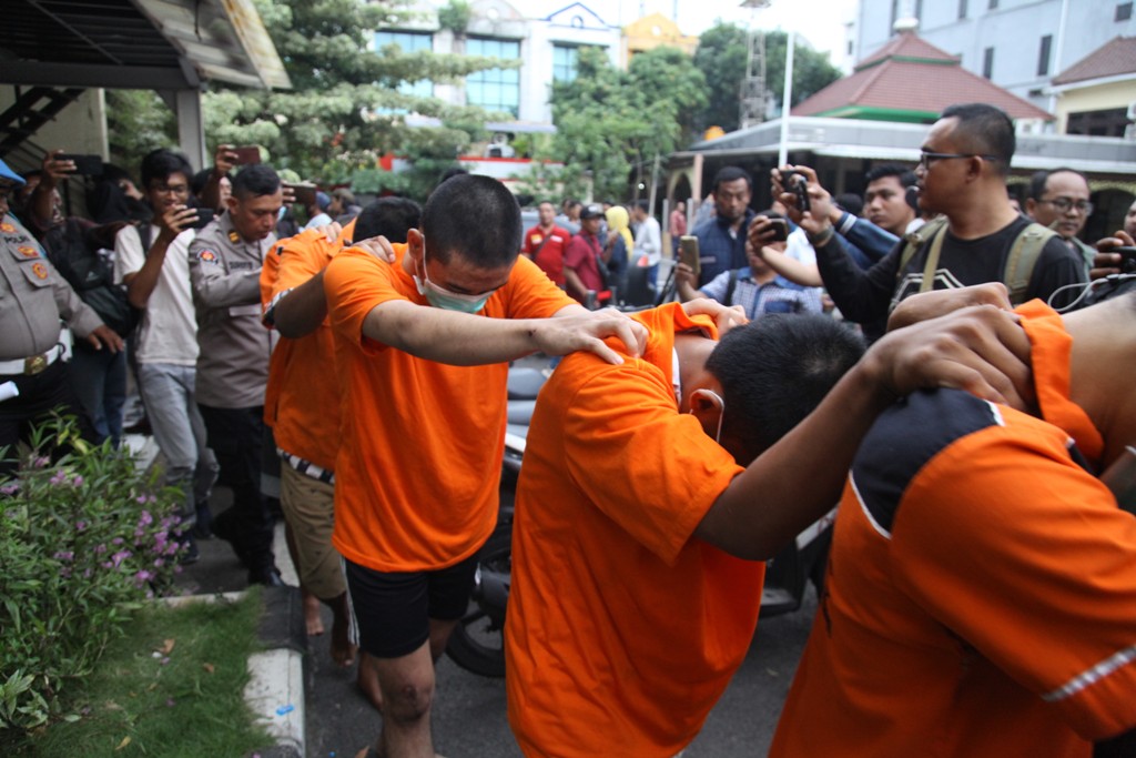 Petugas menunjukkan barang bukti dan tersangka kasus kericuhan suporter dan polisi yang berhasil diamankan di Mapolres Pelabuhan Tanjung Perak, Surabaya, Senin (3/6) siang (SURYANTO/RADAR SURABAYA).