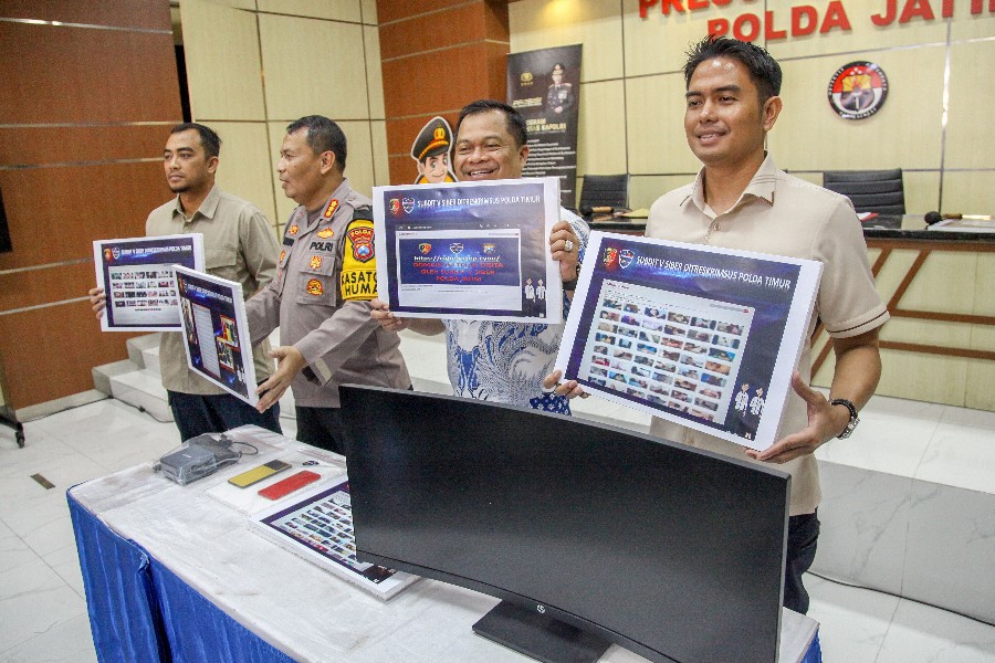 Petugas menunjukkan barang bukti dan tersangka kasus penyebaran konten pornografi yang berhasil diamankan di Mapolda Jatim, Jalan Ahmad Yani, Surabaya, Kamis (6/6).