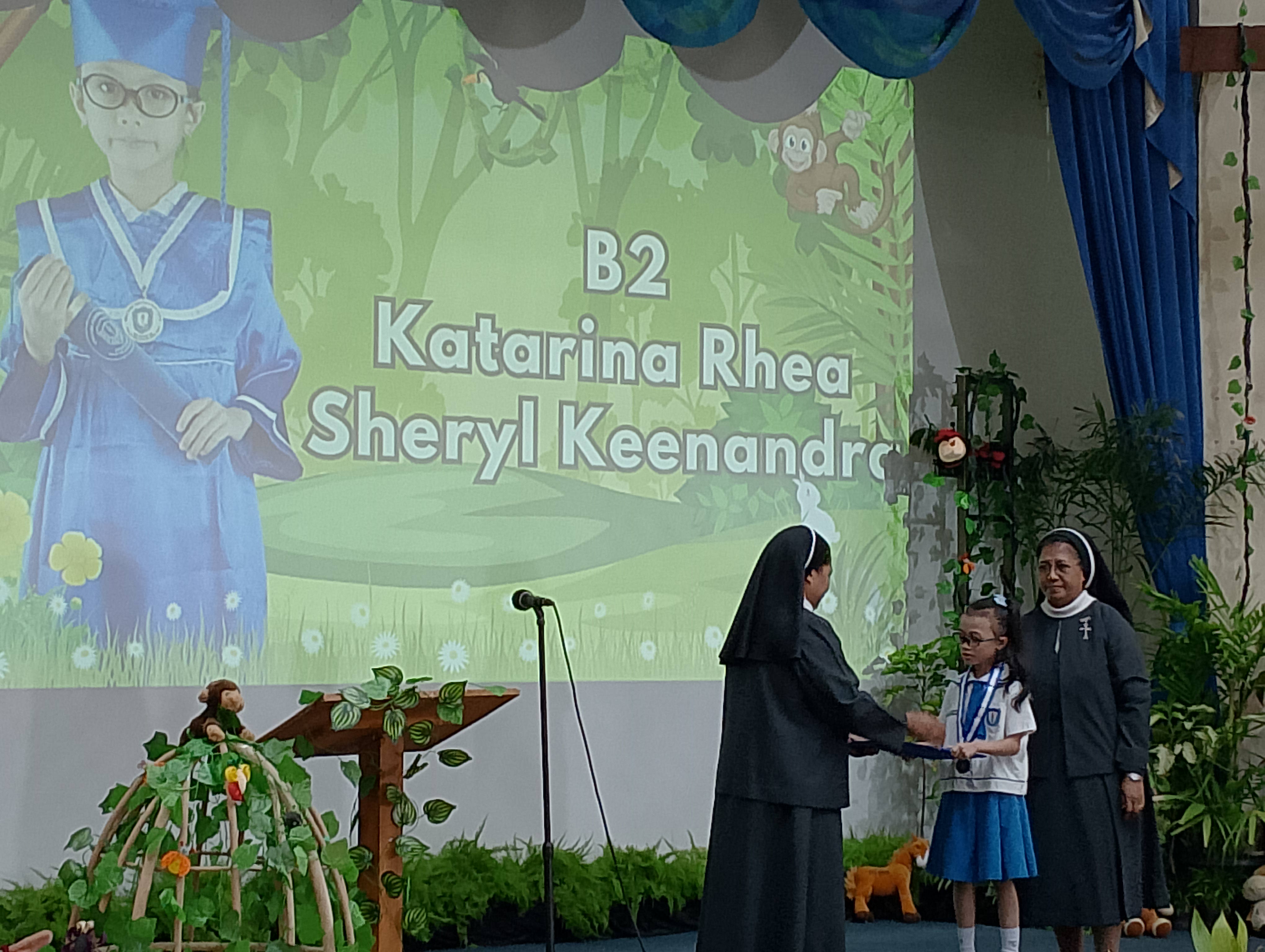 LULUS: Katarina Rhea Sheryl dari kelompok B-2 saat menerima STTTK dari Kepala TK Katolik Santa Clara, Sr. Marselina Siu, MC., M.Pd (kiri) didampingi Ketua Yayasan Puspita Kencana, Sr. Maria Lordes.