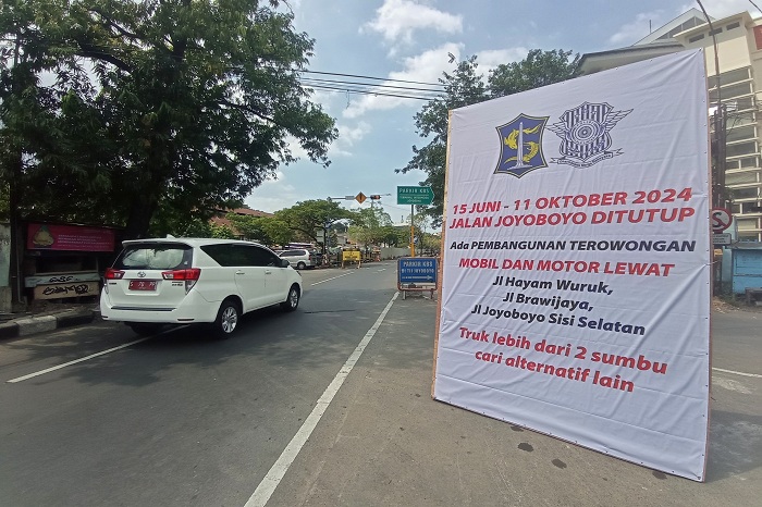 PENGUMUMAN: Pengendara melintas tak jauh dari Terminal Intermoda Joyoboyo (TIJ) di kawasan Wonokromo, Surabaya, Jumat (14/6). (SURYANTO/RADAR SURABAYA)