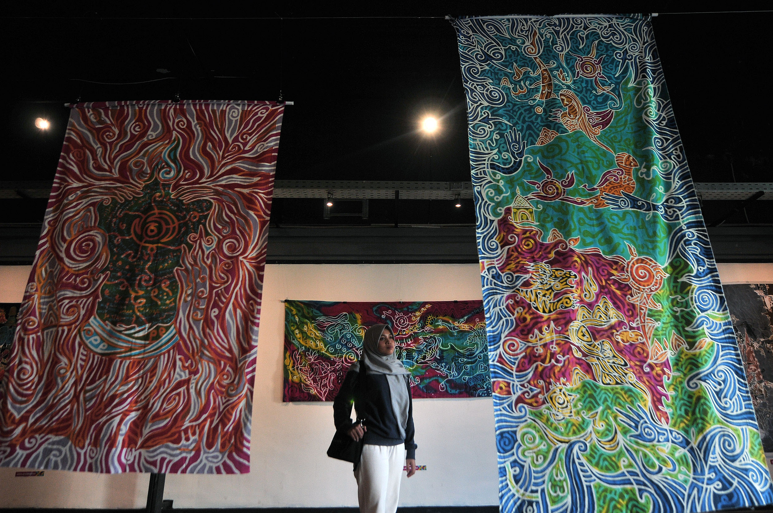 PAMERAN BATIK: Pengunjung mengamati lukisan batik dengan mengangkat tema Batik Ketitik Olo Ketoro, dipamerkan di Galeri DKS, Kompleks Alun-alun Surabaya, Minggu (16/6).