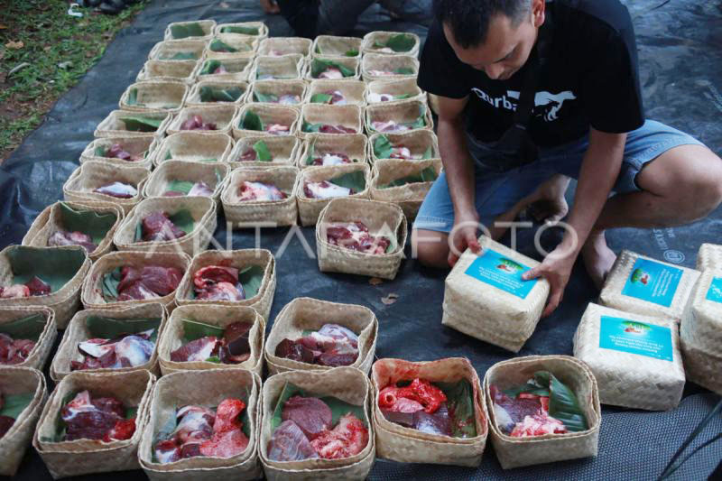 Petugas mengemas daging hewan kurban ke dalam besek bambu saat pemotongan hewan kurban, Senin (17/6).