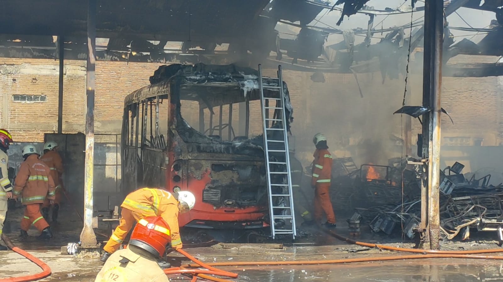 Petugas DPKP Surabaya melakukan pemadaman api yang membakar bus dan mobil di Pool Damri Jalan Jagir, Surabaya Sabtu (22/6). (IST)