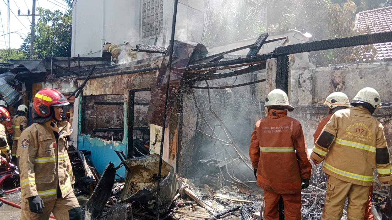 PUING: Petugas DPKP Surabaya memadamkan api yang membakar lima stand di Jalan Tambak Dukuh I Surabaya, Sabtu (29/6) siang.