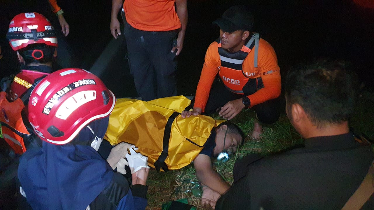 Petugas memberikan pertolongan pertama kepada DN pria yang menceburkan diri di Sungai Jagir, Surabaya. (IST)