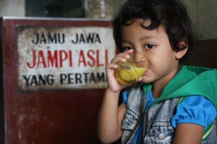 MINUM DULU: Seorang bocah menikmati minuman lewat sebuah gelas kaca.  (ILUSTRASI/NDONESIA.GO.ID)