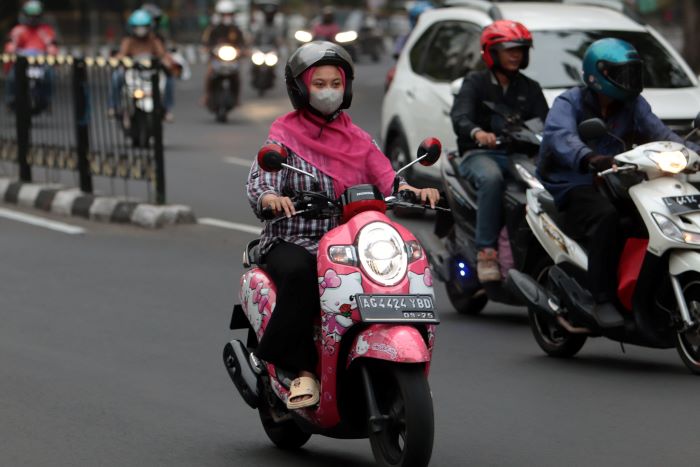 JAGA KESEHATAN: Penting bagi seorang pengendara motor menggunakan masker karena kualitas udara yang tak selalu baik. (ANDY SATRIA/RADAR SURABAYA)