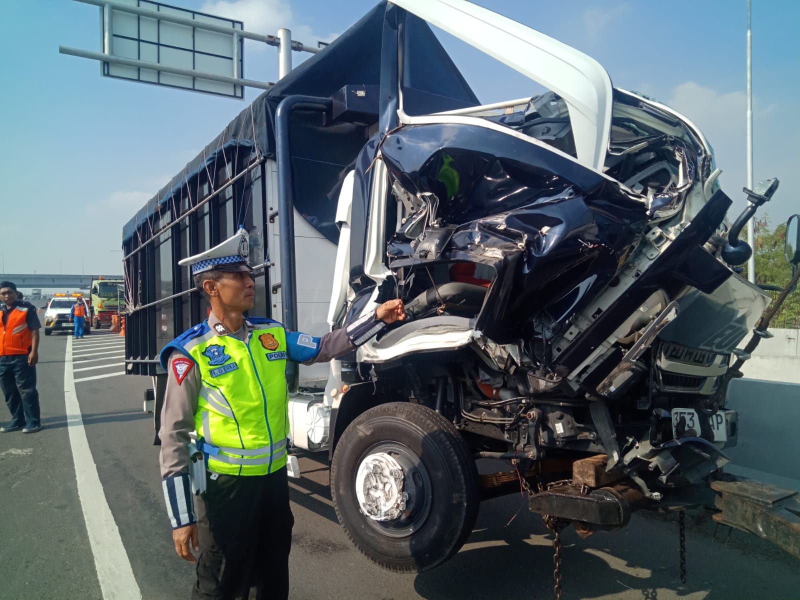Petugas menunjukkan kondisi truk Isuzu yang mengalami kerusakan parah pada bagian depan setelah menabrak samping kiri truk tractor head Hino di KM 8.600/A Tol Tandes Barat Surabaya. (IST)