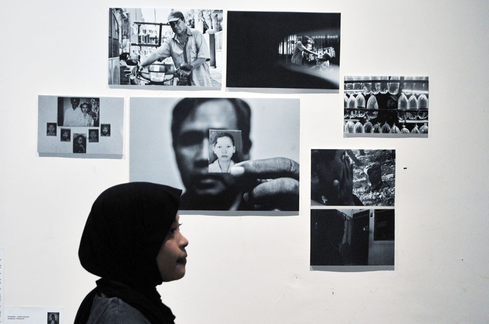 PAMERAN FOTO: Pengunjung mengamati karya foto dengan format story, yang dipamerkan di Galeri DKS, Komplek Balai Pemuda Surabaya, Kamis (11/7).