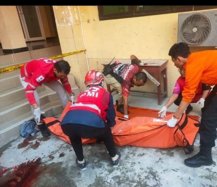 Petugas mengevakuasi jasad korban yang jatuh dari lantai dua gedung sekolah di Jalan Kusuma Bangsa, Surabaya. (IST)