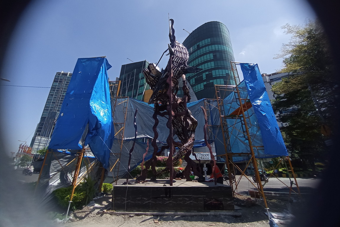 Monumen Suroboyo dari ribuan knalpot borong sedang dikerjakan di perbatasan Surabaya dan Sidoarjo. (SURYANTO/RADAR SURABAYA)