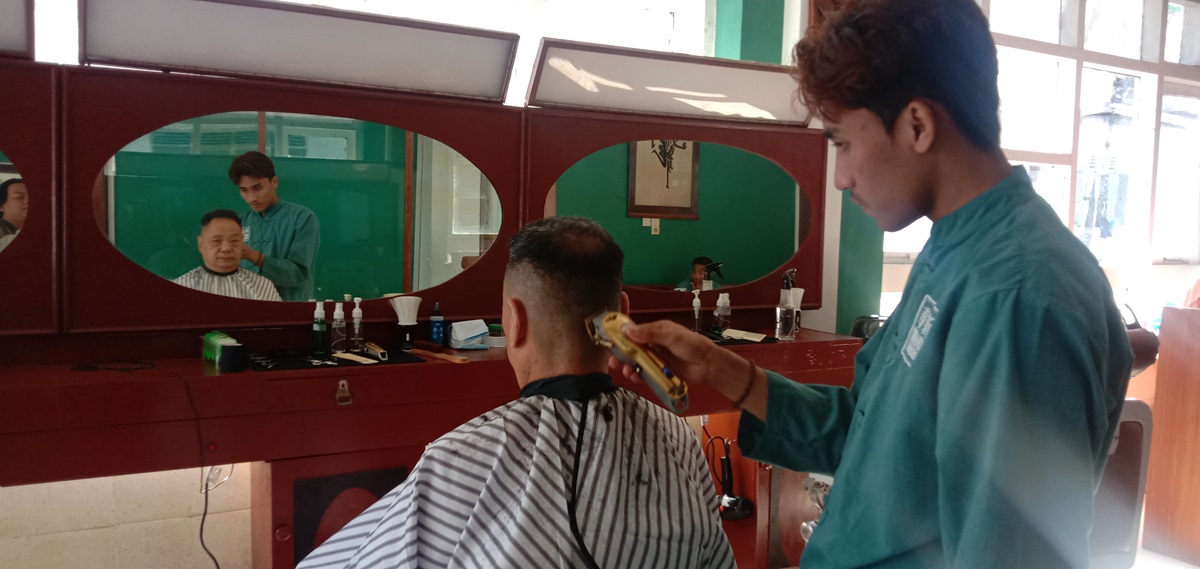 BANGKIT KEMBALI: Barber sedang mencukur rambut pelanggan di Shin Hua Barbershop.