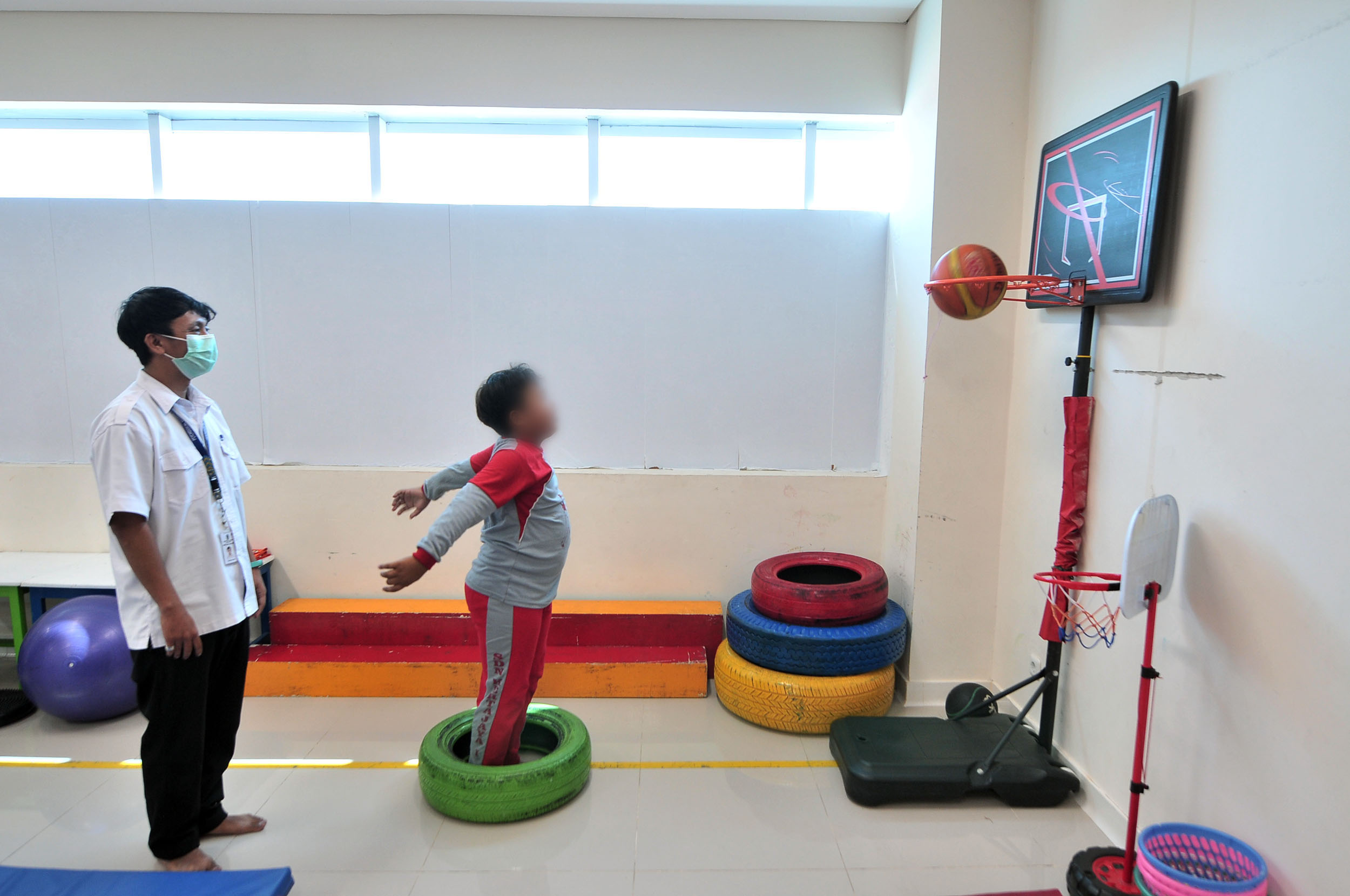 TERAPI: Seorang anak menjalani terapi okupasi dengan didampingi terapisnya di Poliklinik Kesehatan Jiwa Anak dan Remaja, RSJ Menur, Surabaya, Selasa (23/7).