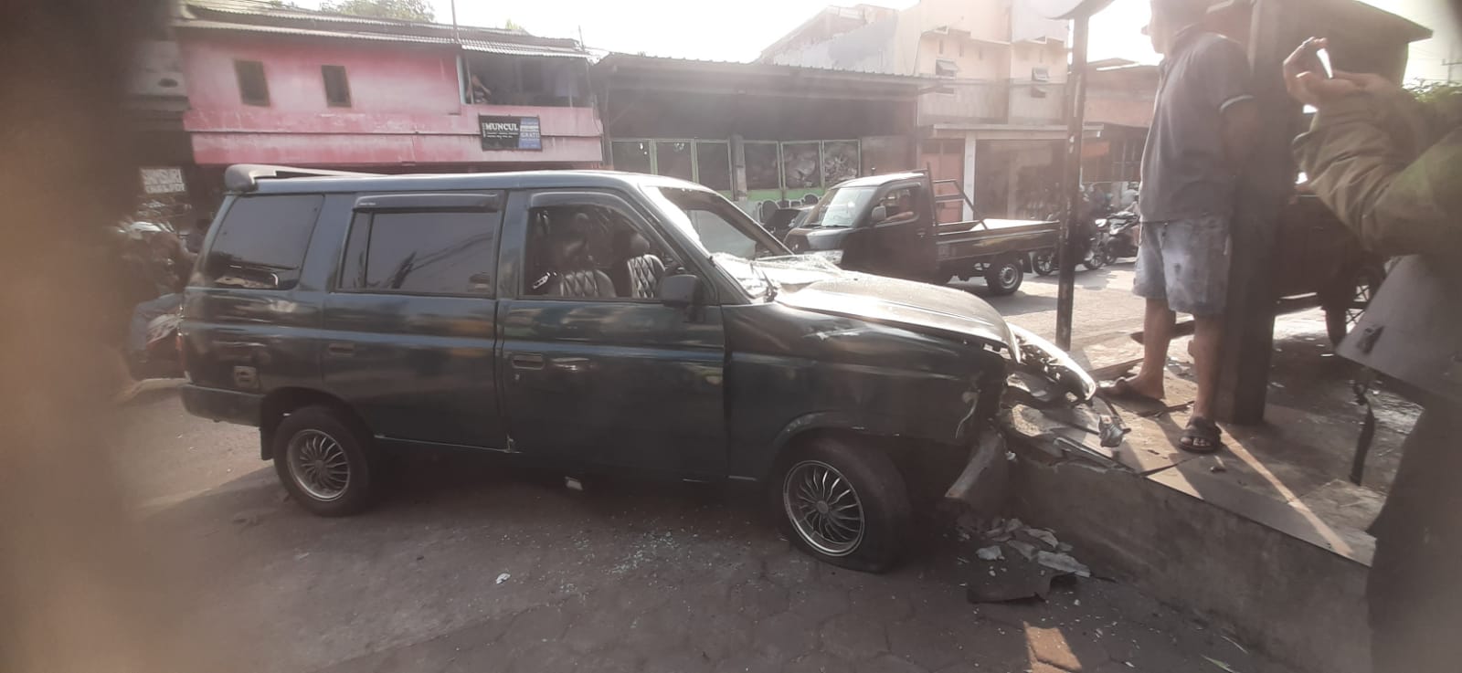 Mobil Panther rusak parah setelah menabrak motor dan tembok pembatas warung di Jalan Ngagel, Surabaya. (Mahrus/Radar Surabaya)