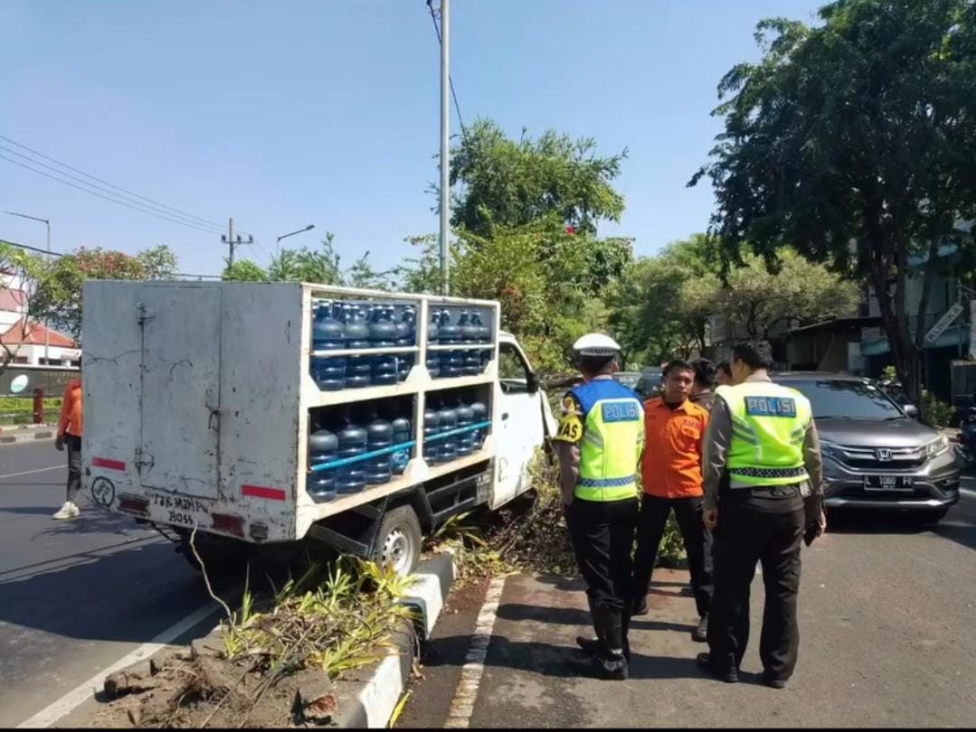 Mobil angkut galon air mineral naik median jalan di Jalan Prof Dr Moestopo, Surabaya, depan kantor PDAM. Mobil tersebut berhenti setelah menabrak pohon. (IST)