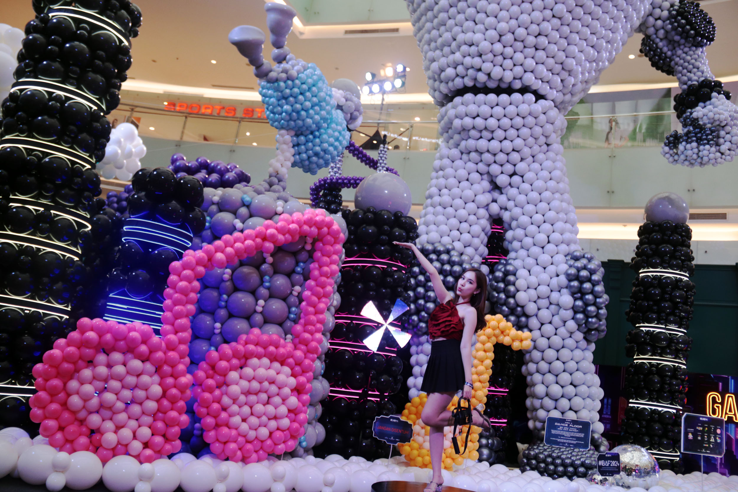 MENARIK: Pengunjung memanfaatkan seni instalasi dari susunan balon dengan berfoto dalam Indonesia Ballon Art Festival 2024 di Ciputra World Surabaya.