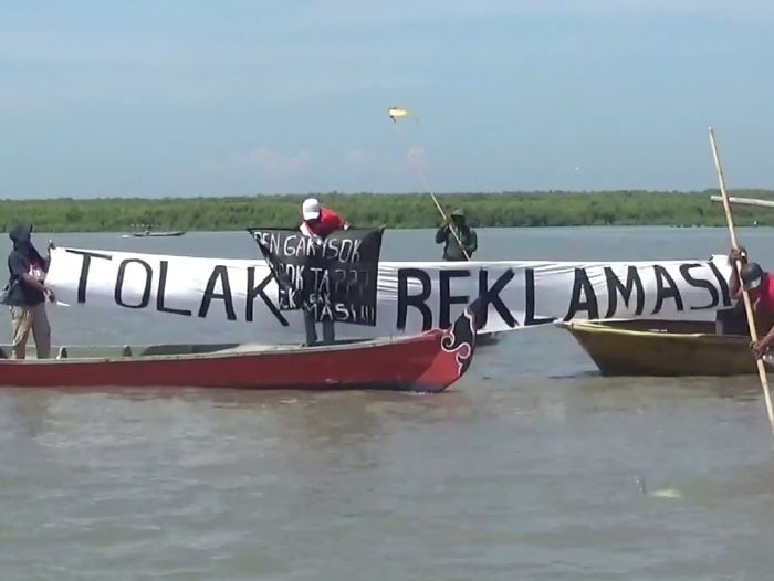 TOLAK: Nelayan, masyarakat dan mahasiswa yang tergabung di Forum Masyarakat Madani Maritim lakukan aksi protes terkait PSN Surabaya Waterfront Land di pesisir Kenjeran, , Sabtu (3/8). (RAHMAT/RADAR)