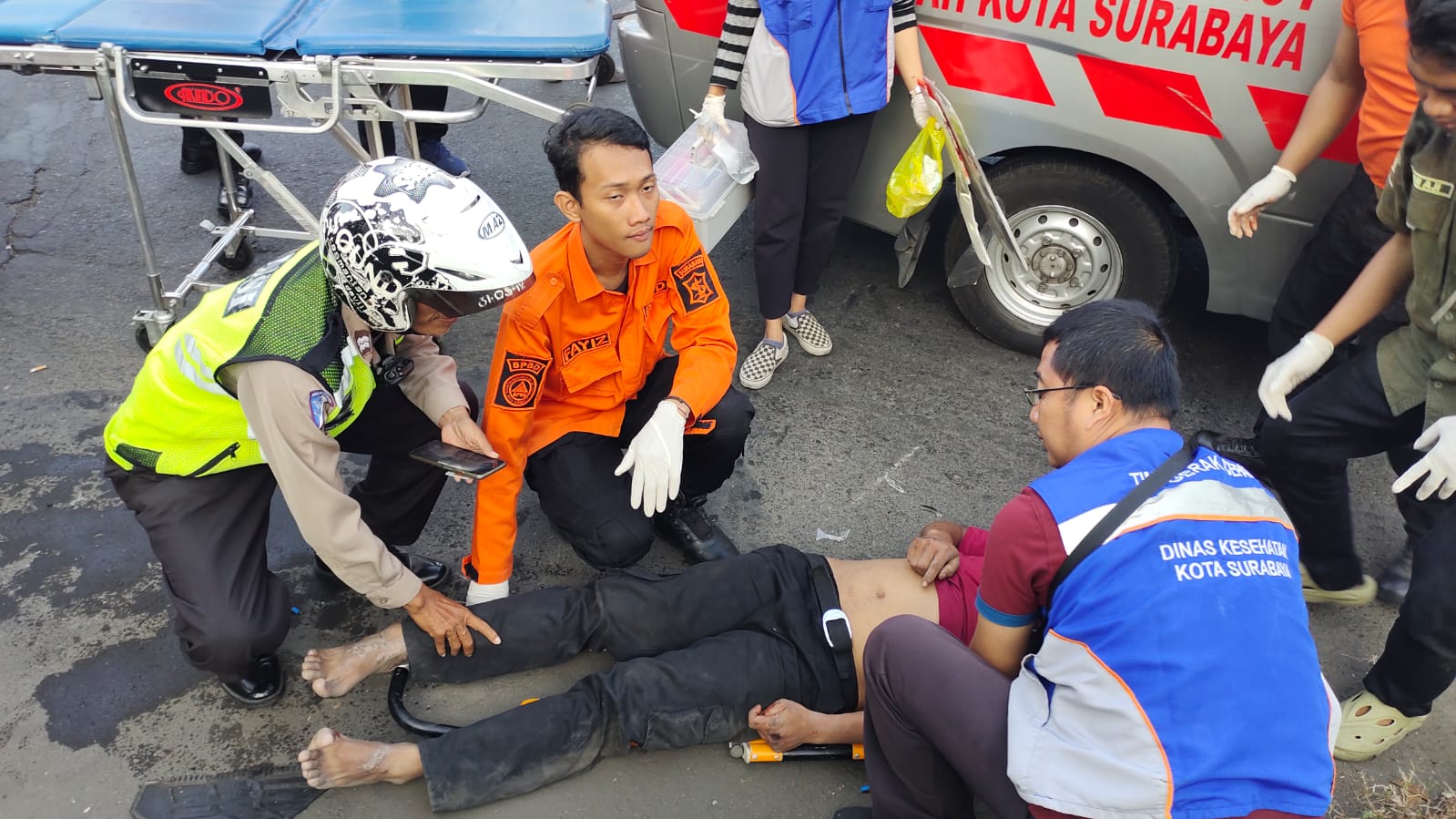Petugas memberikan pertolongan kepada korban laka di perempatan Jalan Ngagel-Jalan Bung Tomo, Surabaya. (IST)