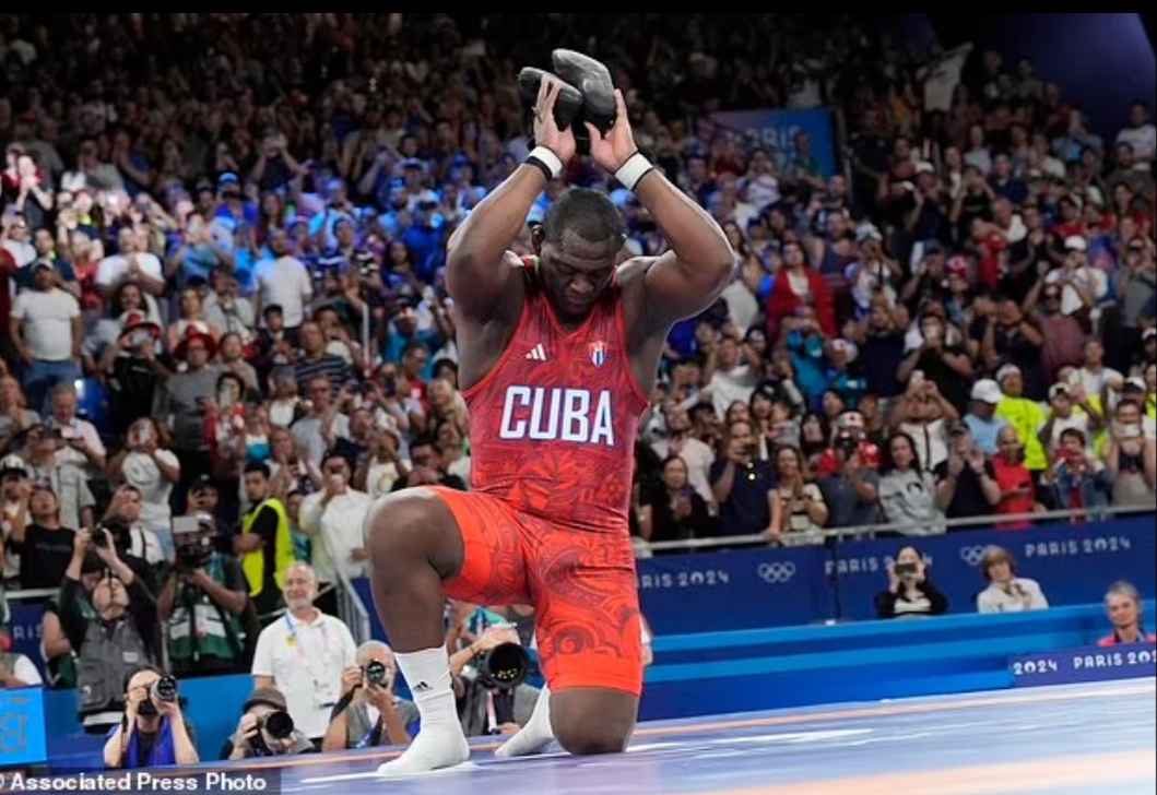 Mijain Lopez Nunez melepas sepatunya sebagai tanda ia akan pensiun setelah mengalahkan Yasmani Acosta Fernandez dari Chili dalam pertandingan final gulat Greco-Roman putra kelas 130kg.