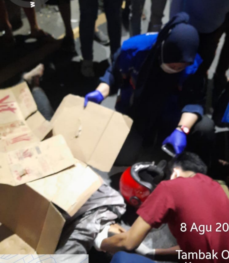Tim medis memeriksa korban Deni Setiawan, 19, pengendara motor yang ditemukan tewas dilindas truk trailer di Jalan Tambak Osowilangun, Surabaya. (IST)