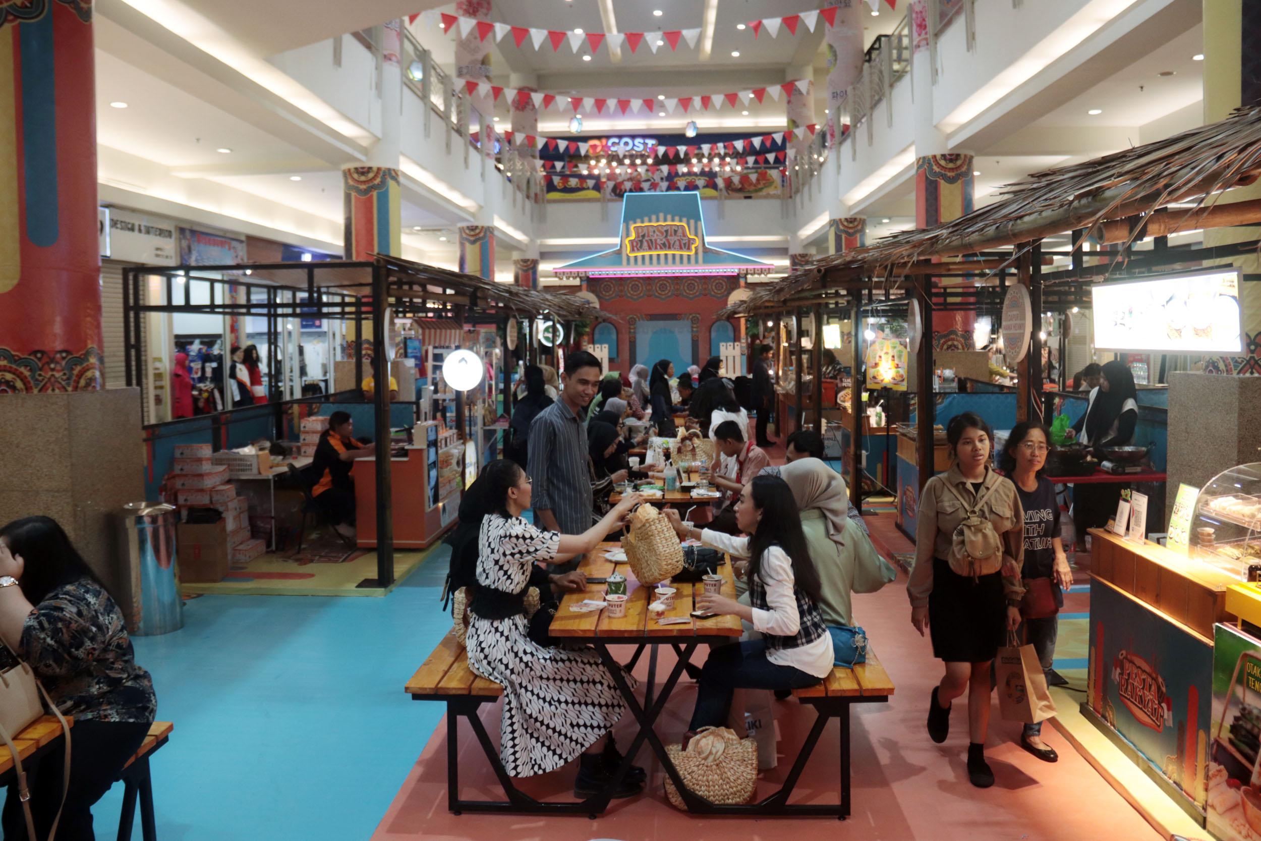 Sejumlah pengunjung menikmati sajian makanan tradisional dalam event Pasar Rakyat di Royal Plaza Surabaya, Jumat (9/8).