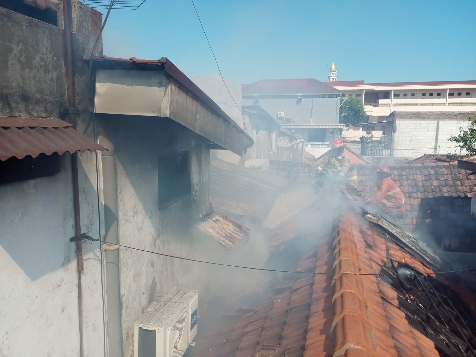 Petugas DPKP Surabaya saat berada di lokasi kebajaran rumah Jalan Irawati, Surabaya. Korban alami luka bakat ringan. (GUNTUR IRIANTO/RADAR SURABAYA)