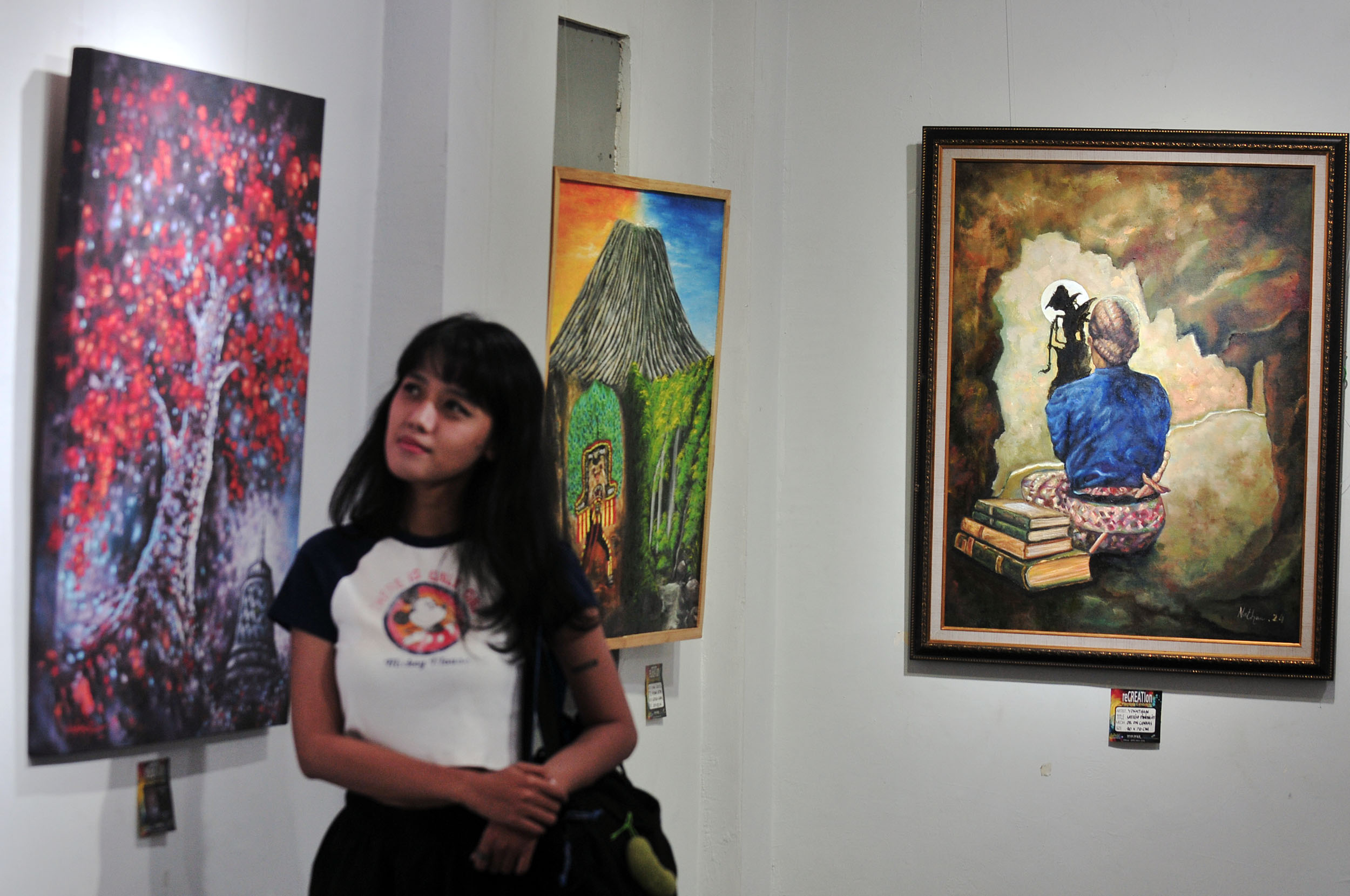 PAMERAN LUKISAN: Pengunjung mengamati karya-karya lukisan dalam pameran bertajuk Recreation Painting Exhibition di Galeri Prabangkara kompleks Taman Budaya Jatim, Surabaya, Selasa (13/8).