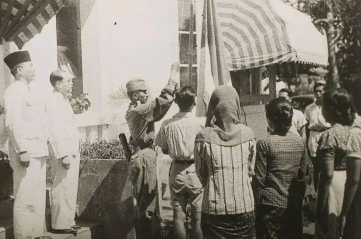 Foto pengibaran bendera merah putih oleh petugas disaksikan dwitunggal Soekarno-Hatta yang berhasil diabadikan Frans Mendur.