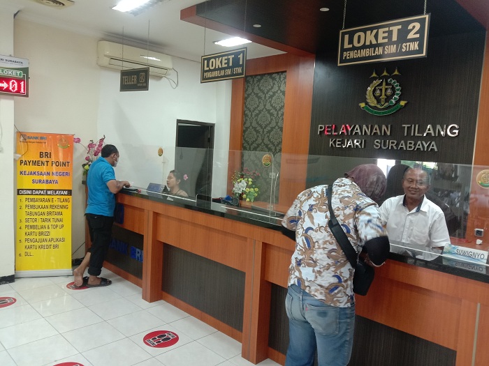 LAYANAN: Petugas layanan tilang di kantor Kejari Surabaya melayani pengambilan surat tilang. (FAJAR YULIYANTO/RADAR SURABAYA)